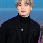 Suga BTS mengenakan setelan hitam saat tampil di depan publik.