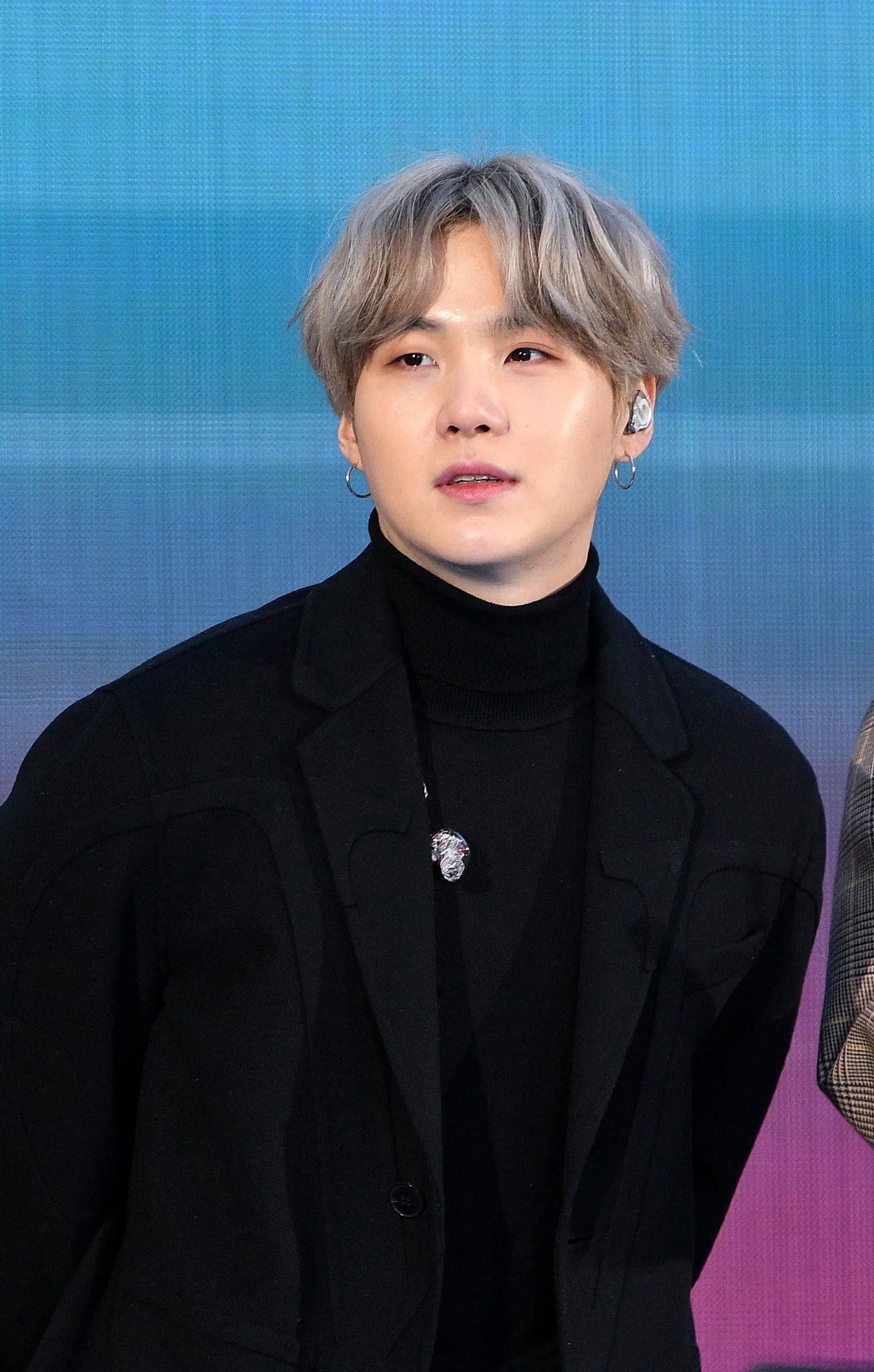 Suga BTS mengenakan setelan hitam saat tampil di depan publik.