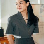 Maudy Ayunda mengenakan blazer abu-abu saat menghadiri acara publik.