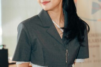 Maudy Ayunda mengenakan blazer abu-abu saat menghadiri acara publik.
