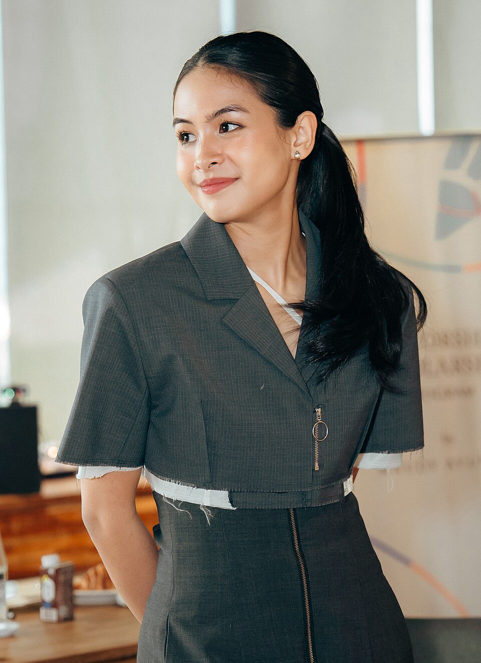 Maudy Ayunda mengenakan blazer abu-abu saat menghadiri acara publik.