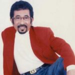 Hamdan ATT tersenyum dengan jas merah.