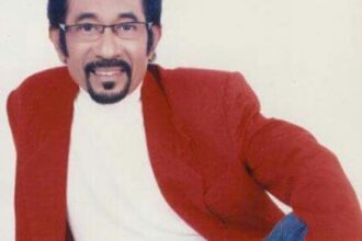 Hamdan ATT tersenyum dengan jas merah.