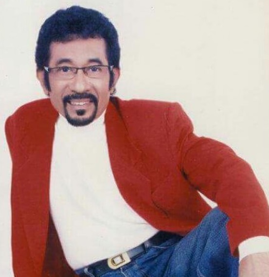 Hamdan ATT tersenyum dengan jas merah.
