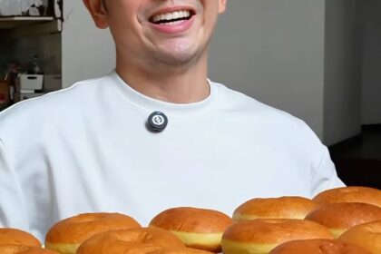 Nicky Tirta tersenyum sambil memamerkan donat buatannya.