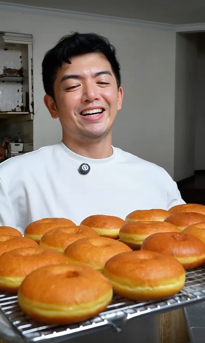 Nicky Tirta tersenyum sambil memamerkan donat buatannya.